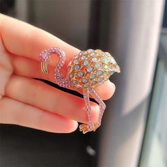 stylish flamingo brooch on fabric background
