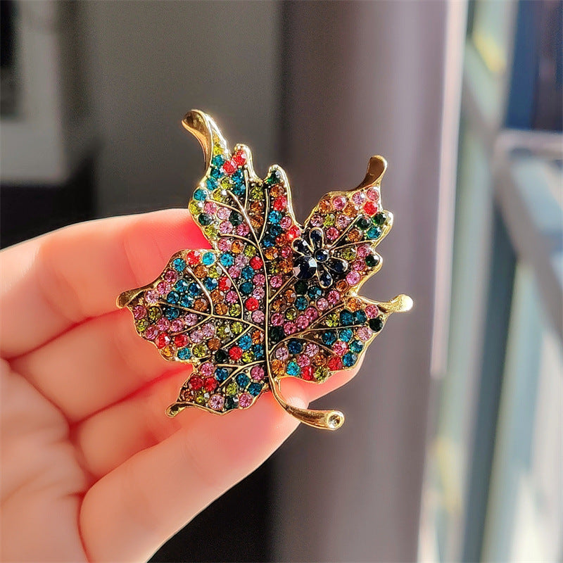 Side view of vintage leaf brooch with vivid rhinestones