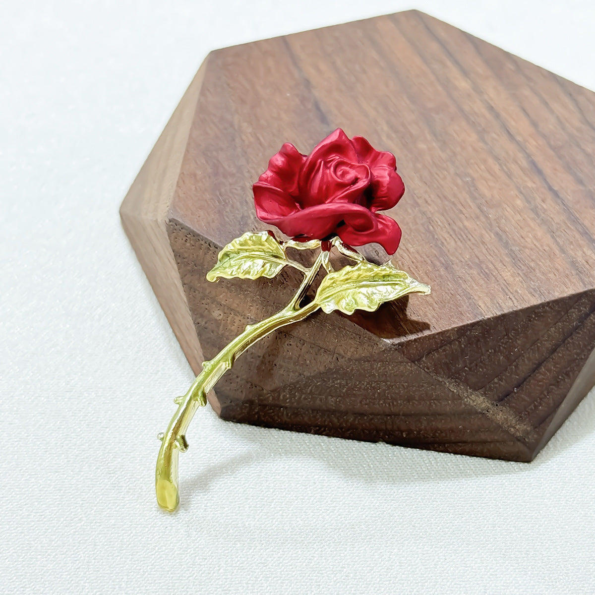 red rose brooch in a fashionable setup