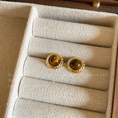 Close up of metal and tiger eye stone earrings